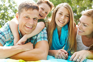 Image showing Relaxing in the park together. A happy young family lying on the ground together at the park.