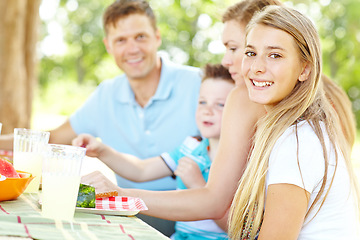 Image showing Enjoying a summer picnic together. A happy young family relaxing in the park and enjoying a healthy picnic.