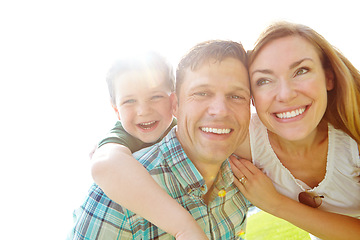 Image showing Enjoying the sunshine. A cute young family spending time together outdoors on a summers day.