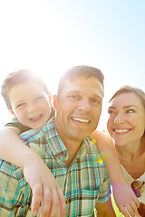 Image showing Enjoying time with his family. A cute young family spending time together outdoors on a summers day.