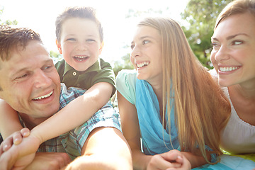 Image showing Enjoying some family quality time. A happy young family lying on the ground together at the park.