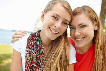 Image showing Two peas in a pod. Smiling mother and daughter embracing while outdoors.