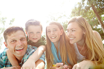 Image showing Enjoying a day in the park. A happy young family lying on the ground together at the park.