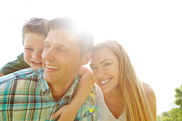 Image showing Secure in his parents love. A cute young family spending time together outdoors on a summers day.