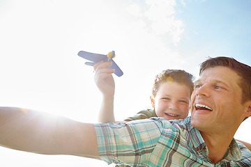 Image showing Lets make it soar. A cute little boy playing with an airplane while being carried on his fathers back.