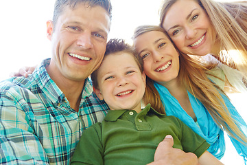 Image showing Theyre a close-knit family. A cute young family spending time together outdoors on a summers day.