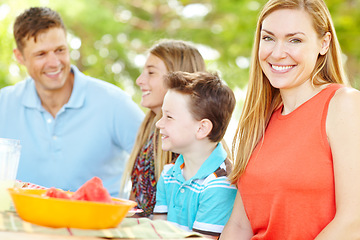 Image showing Proud of her beautiful family. A happy young family relaxing in the park and enjoying a healthy picnic.