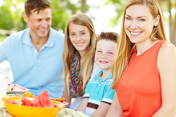 Image showing Shes so proud of her loving family. A happy young family relaxing in the park and enjoying a healthy picnic.