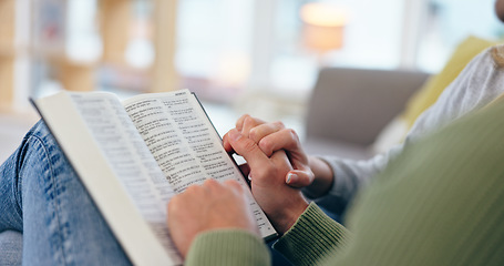 Image showing Couple holding hands, bible and closeup in home for reading with faith, spiritual knowledge and bonding. People, zoom and book for hope, worship or connection to God in living room for peace in house