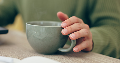 Image showing Closeup, hand and cup for coffee in home for relaxing, comfort or delicious taste in morning. Person, entrepreneur and remote work with hot beverage, tea or cappuccino for drinking on table in office