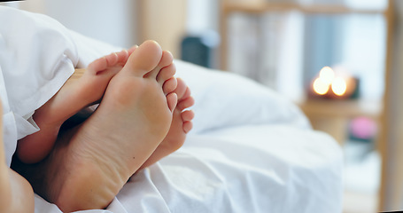 Image showing Feet, love and a couple sleeping in bed together for romance or bonding in their home in the morning. Relax, dating or playful with a man and woman barefoot in the bedroom of their apartment closeup