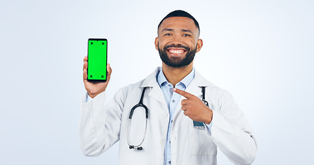 Image showing Phone, green screen and portrait of doctor pointing to promo or registration in white background. Studio, healthcare or sign to offer, information or telehealth mobile app, services or presentation