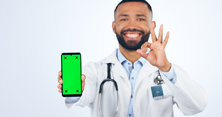 Image showing Phone, okay sign and portrait of doctor with green screen agreement or registration in white background. Studio, healthcare or hand for ok, yes and mobile app success for telehealth services mockup