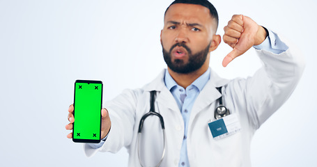 Image showing Phone, green screen and portrait of doctor with thumbs down, review or fake news in white background. Studio, healthcare or sign for negative, feedback and dislike mobile app for telehealth services