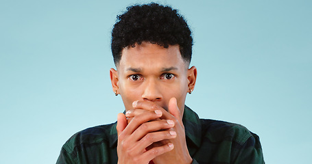 Image showing Anxiety, fear and hands on face of man in studio with emoji surprise, news or horror on blue background. Stress, danger and portrait of model with wow reaction to mistake, crisis or trauma conflict