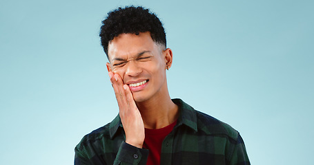 Image showing Man, toothache or pain in studio with gum problem, cavity or dental crisis by blue background. Model, face and hands by teeth care for tmj, gingivitis and oral decay or orthodontics help in mockup