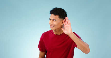 Image showing Portrait, overhearing and hand gesture for eavesdropping with a man listening in studio on a blue background. Emoji, communication and secret with a confused young person in doubt about news
