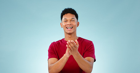 Image showing Man, portrait and clapping for celebration in studio for goal growth, winning or opportunity. Male person, face and hand applause on blue background as mockup or achievement, congratulations or pride