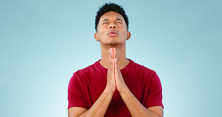 Image showing Religion, praying and young man in a studio for hope, gratitude and spiritual expression. Prayer, christian and male person from Mexico speaking for worship to god isolated by blue background.