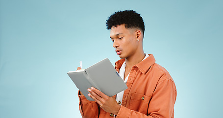 Image showing Thinking, notebook and writing with man, planning and ideas with creativity on a blue studio background. Person, guy and model with problem solving, vision or education with student and knowledge