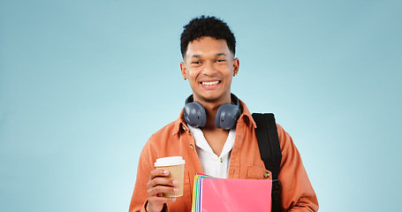 Image showing Student, coffee and portrait of man with books and backpack in studio for university or college. Education, happy and person smile with headphones, notebooks and bag for learning on blue background