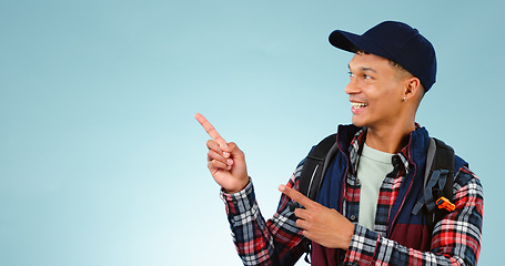 Image showing Happy, backpack and man in studio pointing for choice, decision and option on blue background. Travel, tourist mockup and isolated excited person with hand gesture for hiking, adventure and vacation