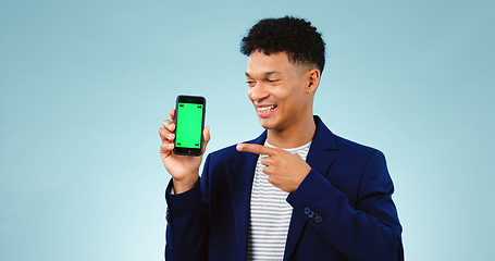 Image showing Business man, phone green screen and presentation for stock market, trading software or registration in studio. Young trader pointing to mobile app or website mockup isolated on a blue background