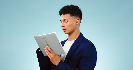Image showing Man in studio, writing in notebook for ideas and business research for creative startup schedule. Thinking, agenda and young professional businessman with notes, pen and to do list on blue background
