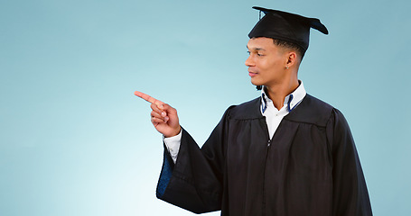 Image showing Education, graduation and a student man pointing to space in studio on a blue background for marketing. School, university or college with a confident young graduate on mockup for advertising