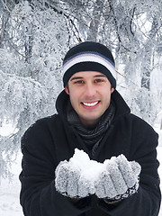 Image showing Smiling man holding snow