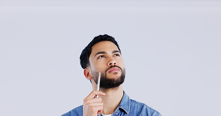 Image showing Thinking, face and man with pen in studio looking up at mockup for brainstorming on grey background. Idea, questions and model with problem solving, planning or emoji for solution, guess or choice