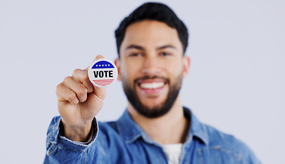 Image showing Vote, smile and portrait of man with badge in studio for choice, decision or registration on grey background. Government, politics and face of happy voter with support, freedom and party election