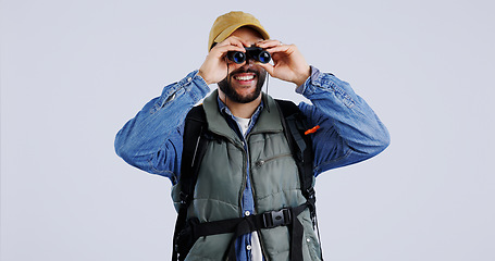 Image showing Hiking, backpack and happy man with binocular search in studio for travel, freedom or adventure on grey background. Camping, journey and backpacker with explore equipment for bird watching in nature