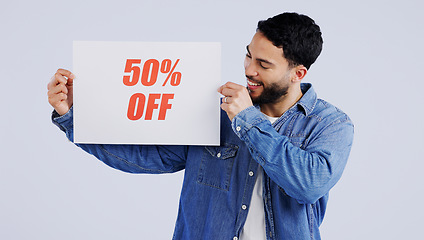 Image showing Happy man, sign and sale in discount, promotion or banner against a gray studio background. Male person or model smile with billboard, poster or half price in advertising or marketing for store promo