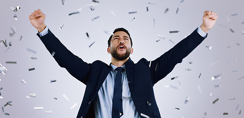 Image showing Happy businessman, fist pump and confetti in celebration, winning or achievement against a gray studio background. Excited man employee in party prize, good news or business promotion for success