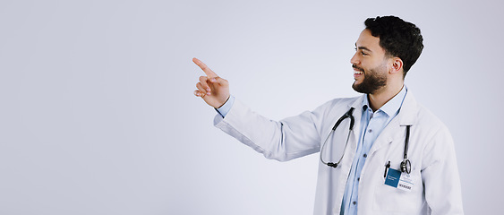 Image showing Smile, man and doctor pointing at presentation, show mockup and space on a white background. Happy medical professional gesture at advertising, announcement or information, healthcare and marketing