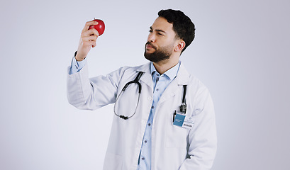 Image showing Healthcare, doctor and thinking with apple in studio for mockup in nutrition on white background. Mexican person, male model or medical professional by red fruit in vegan, vegetarian or diet in space