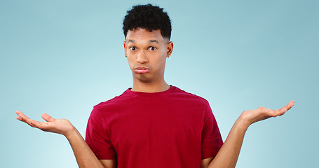 Image showing Portrait, man and shrug for doubt in studio for promotion with mock up for option, decision or choice. Male model, face and unsure or confused with presentation, scale or deal on blue background