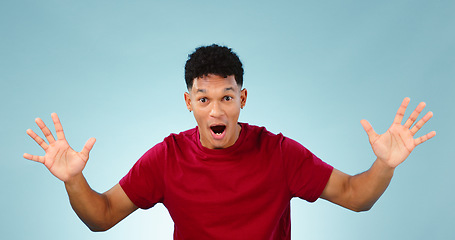 Image showing Man, surprise and happy for prize, portrait or excited with face, good news and blue studio background. Energy, winning and wow for achievement, competition and hands for success, winner and offer