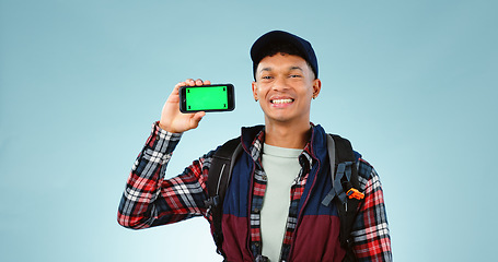 Image showing Hiking, green screen and man with a smartphone, portrait and backpack on a blue studio background. Person, hiker and model with mockup space, digital app and cellphone with tracking markers or travel