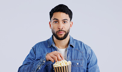 Image showing Television, portrait and man with popcorn in studio for movie, film or documentary on grey background. Cinema, watching tv and face of model with theater snack for video, entertainment or streaming