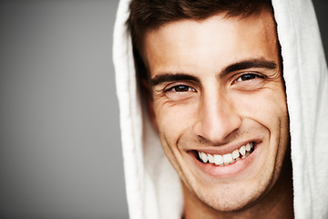 Image showing Portrait, smile and man in hoodie for fashion isolated on a gray studio background mockup space. Happy person, face of model and stylish clothes, casual or cool facial expression in Spain on backdrop