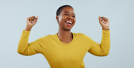 Image showing Excited black woman, dancing and celebration for winning or promotion against a gray studio background. Face of happy African female person or model in joy or satisfaction for bonus or good news