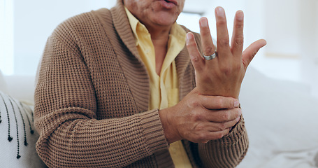 Image showing Hand, wrist pain and injury with an elderly person on a sofa in the living room of a home to massage a joint. Medical, anatomy or ache and a senior in his apartment with arthritis or carpal tunnel