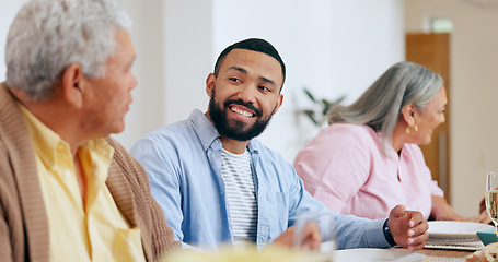 Image showing Family, food and smile the dinner table with a man taking to his senior father while eating a meal together. Feast, conversation and festive celebration with a group of people chatting in a home