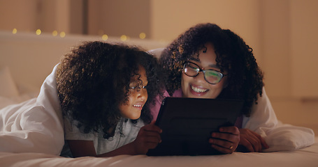 Image showing Mom, daughter and tablet at night with internet for movie, cartoon or streaming with blanket on bed in bedroom. Family, woman and girl child with technology in the dark for film, video and bonding