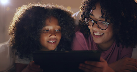 Image showing Mother, daughter and tablet at night with internet for movie, cartoon or streaming with blanket on bed in bedroom. Family, woman and girl child with technology in the dark for film, video and bonding