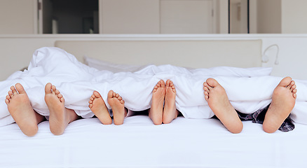 Image showing Family, feet and bed with blanket for sleeping, relaxing or rest together with calm and peace in home. People, parents and children with duvet in morning on vacation, holiday or hotel on weekend