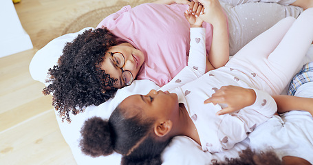 Image showing Mother, daughter and bonding on bed with relax, peace and happiness in bedroom of family home in morning. People, woman or girl child together with pyjamas for rest, love and care with smile in house