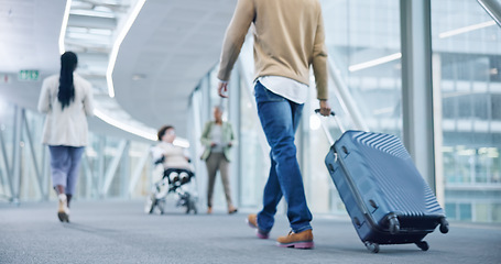 Image showing Closeup, walking and man with a suitcase, back and airport to travel, vacation or holiday in airline hallway. Luggage, legs and person on flight terminal, immigration journey or international trip